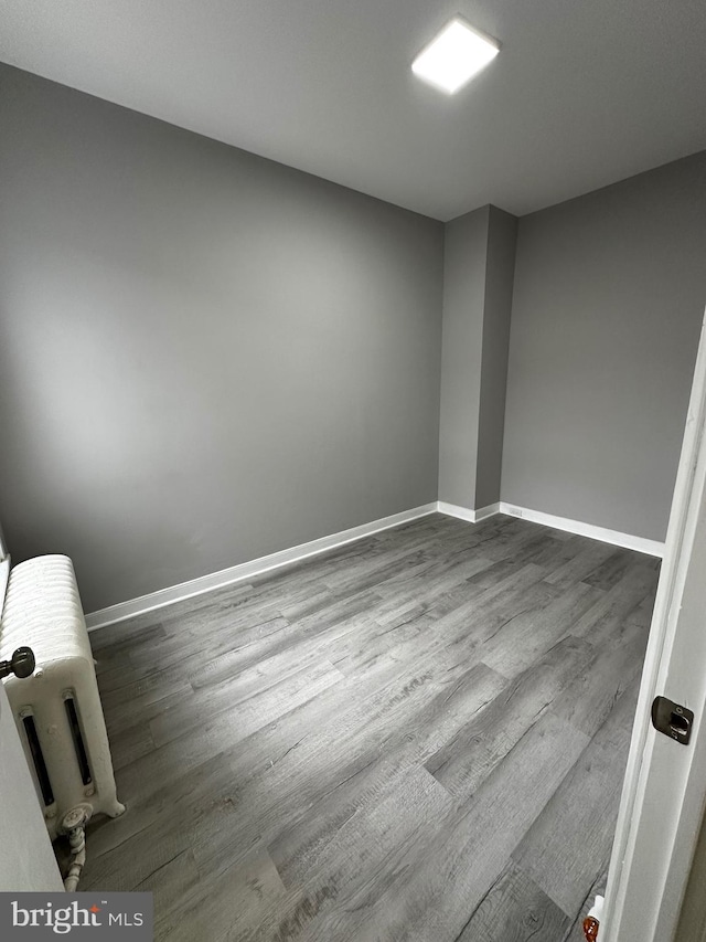 spare room with dark wood finished floors and baseboards