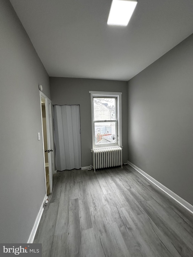 interior space with baseboards, wood finished floors, and radiator