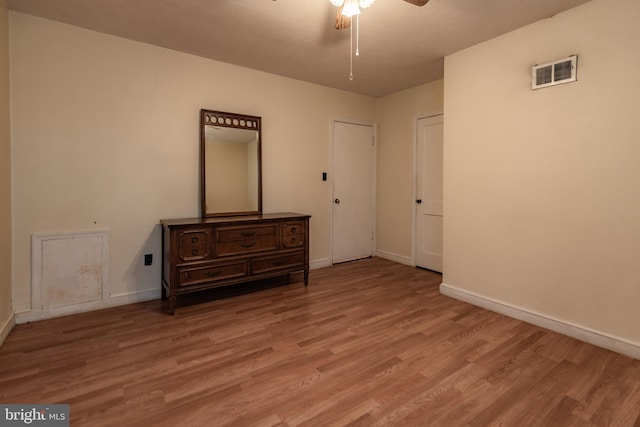 unfurnished bedroom with light wood finished floors, visible vents, and baseboards