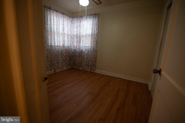 empty room featuring a ceiling fan, baseboards, and wood finished floors