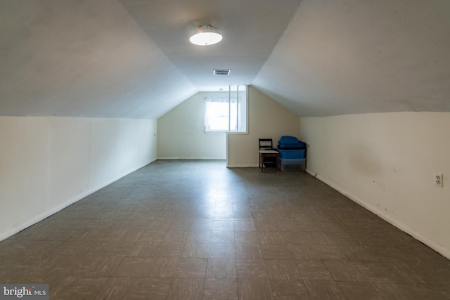 additional living space featuring lofted ceiling, baseboards, and visible vents