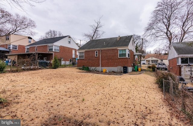 rear view of house with a residential view, fence, and brick siding