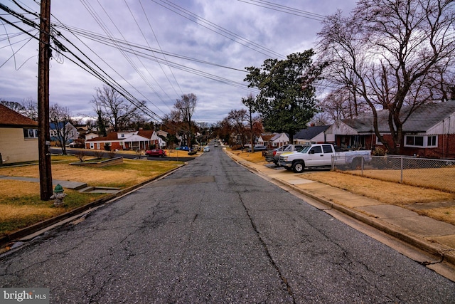 view of street featuring a residential view and curbs