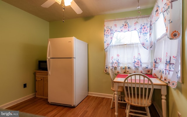 kitchen with ceiling fan, wood finished floors, freestanding refrigerator, and baseboards