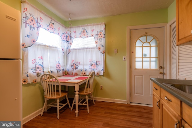 dining space with wood finished floors and baseboards