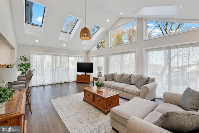 living area featuring recessed lighting, high vaulted ceiling, a skylight, and hardwood / wood-style flooring