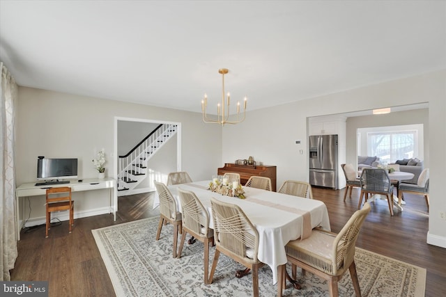 dining room featuring dark wood finished floors, a notable chandelier, stairs, and baseboards