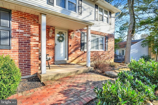 entrance to property featuring brick siding