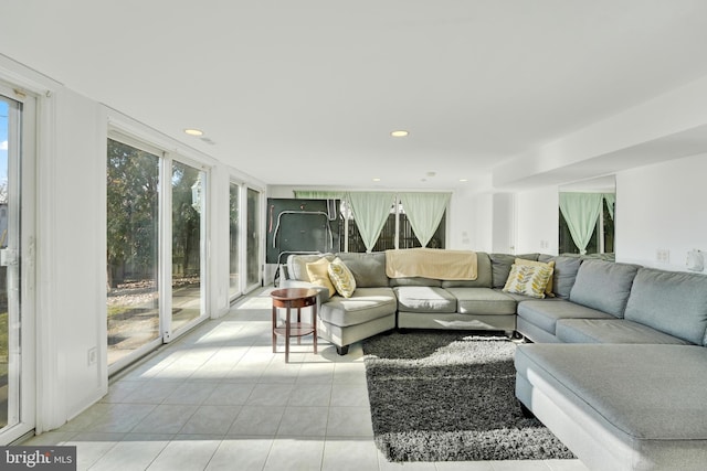 living room featuring light tile patterned flooring, recessed lighting, and a wall of windows