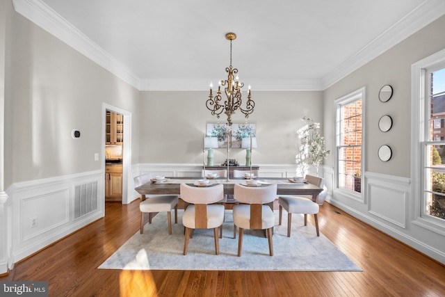 dining room featuring wainscoting, visible vents, hardwood / wood-style floors, and an inviting chandelier