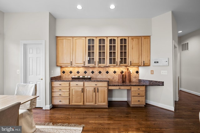 kitchen with glass insert cabinets, visible vents, dark wood finished floors, and light brown cabinetry