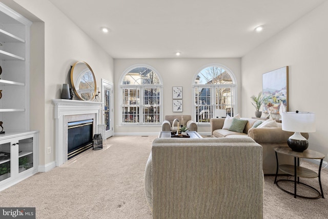 living room featuring recessed lighting, carpet, baseboards, and a high end fireplace