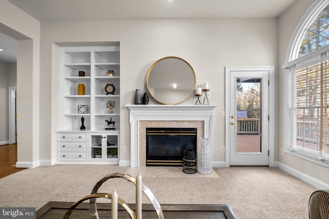 carpeted living room with a healthy amount of sunlight, a fireplace, and baseboards