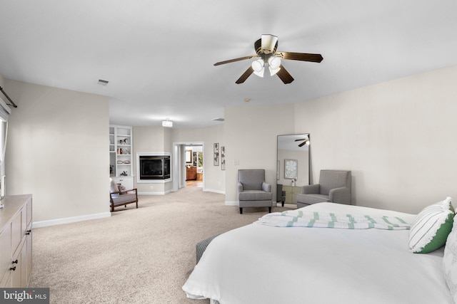 carpeted bedroom featuring a ceiling fan, baseboards, visible vents, and a multi sided fireplace