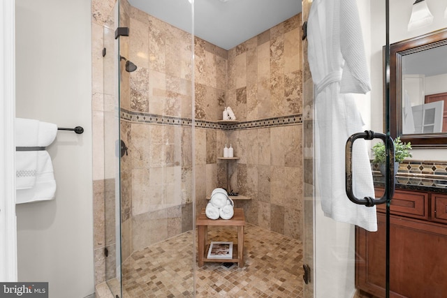 full bath with a tile shower and vanity