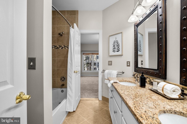 bathroom with a sink, baseboards, tile patterned floors, double vanity, and shower / bath combo with shower curtain