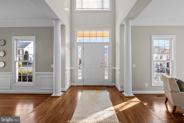 entryway featuring ornamental molding, a healthy amount of sunlight, and ornate columns