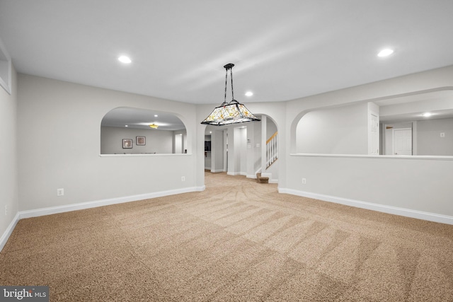 interior space with arched walkways, carpet, recessed lighting, stairway, and baseboards