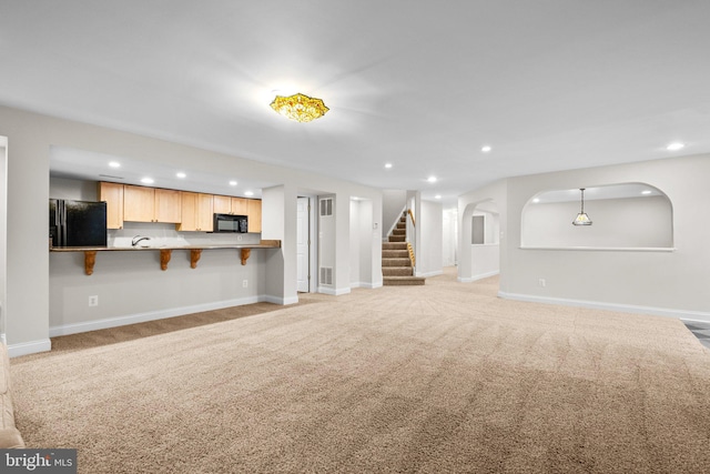 unfurnished living room with light carpet, stairs, baseboards, and recessed lighting