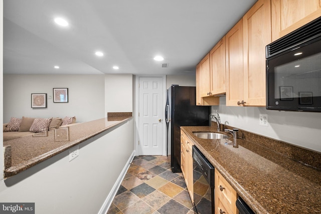 kitchen with stone finish flooring, light brown cabinetry, black appliances, a sink, and recessed lighting