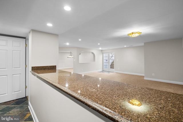 kitchen with recessed lighting, french doors, dark stone counters, and baseboards