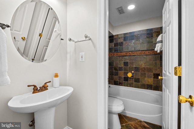 bathroom featuring toilet, visible vents, and bathing tub / shower combination