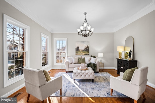 living area with baseboards, visible vents, an inviting chandelier, and wood finished floors