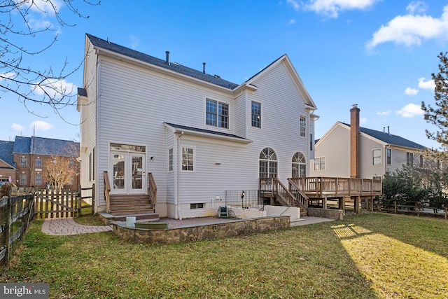 back of house with entry steps, a patio, a deck, a fenced backyard, and a lawn