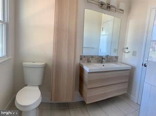 bathroom featuring tile patterned floors, toilet, vanity, and baseboards