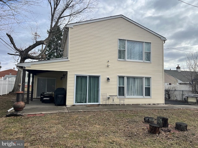 rear view of property featuring a patio and fence