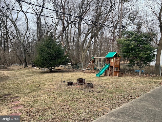 view of jungle gym with a lawn and fence