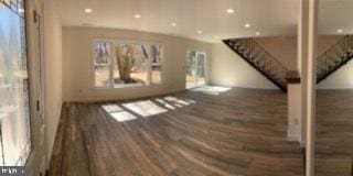 unfurnished living room with stairway, recessed lighting, and wood finished floors