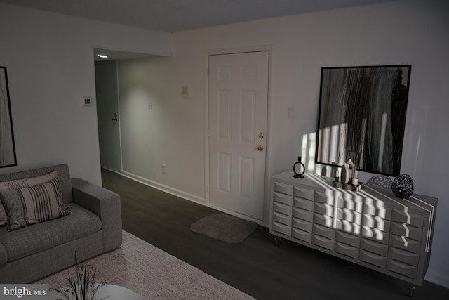 living area with baseboards and wood finished floors