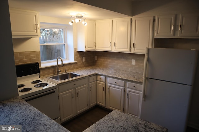 kitchen with range with electric stovetop, white cabinetry, freestanding refrigerator, and a sink