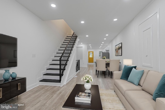 living room with light wood finished floors, baseboards, stairway, and recessed lighting