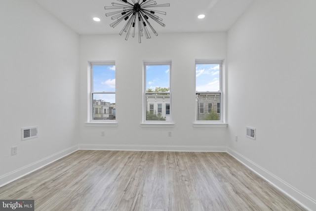 empty room featuring baseboards, visible vents, and recessed lighting