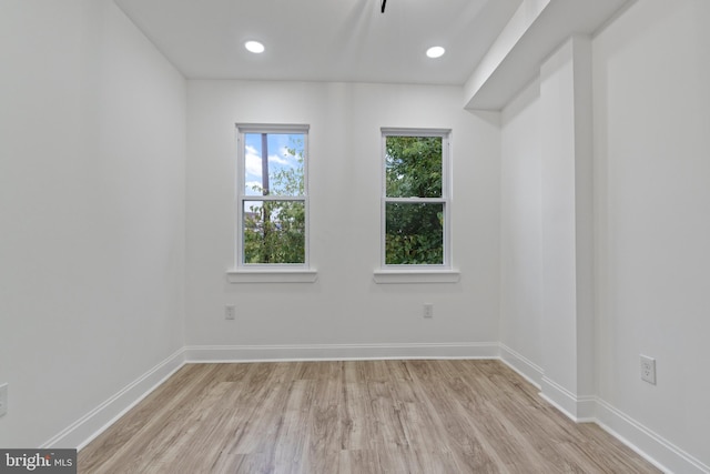 spare room with light wood finished floors, recessed lighting, and baseboards