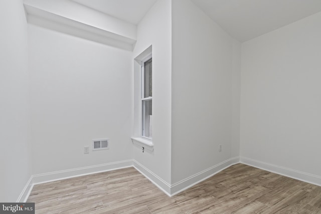 unfurnished room with light wood-type flooring, visible vents, and baseboards