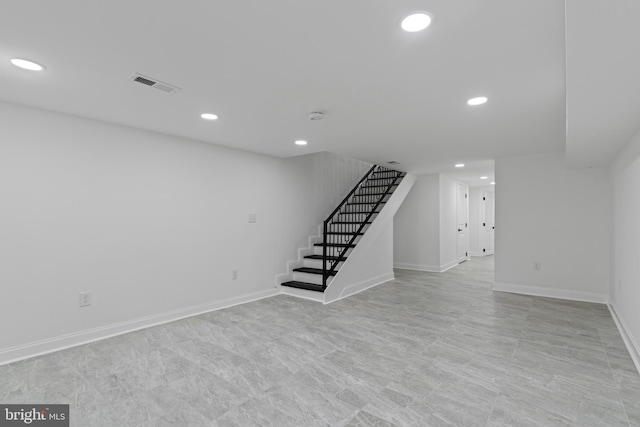 finished basement featuring baseboards, stairway, visible vents, and recessed lighting