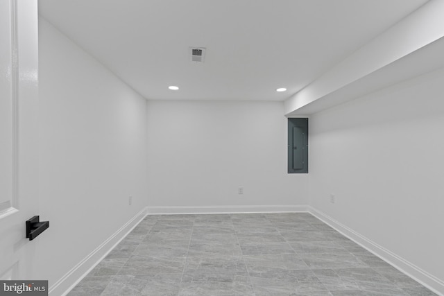 finished basement with visible vents, recessed lighting, electric panel, and baseboards