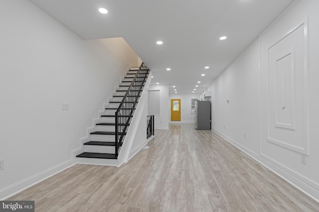 interior space featuring light wood finished floors, stairway, and recessed lighting