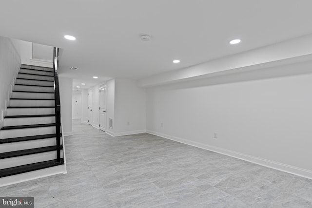 finished basement featuring baseboards, stairway, and recessed lighting