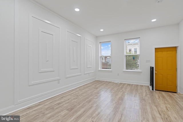 empty room featuring light wood finished floors, baseboards, and recessed lighting