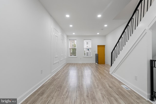 interior space featuring visible vents, baseboards, light wood-style flooring, stairway, and recessed lighting