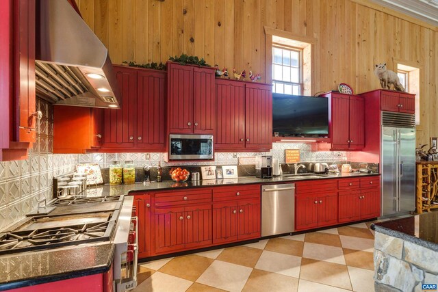 240 Stoneleigh Rd, Palmyra, VA 22963 - kitchen with high end appliances, exhaust hood, tasteful backsplash, light flooring, and wooden walls