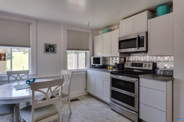 240 Stoneleigh Rd, Palmyra, VA 22963 - kitchen featuring appliances with stainless steel finishes, decorative backsplash, dark countertops, and white cabinetry