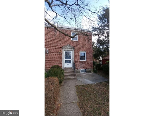 view of front facade featuring entry steps and brick siding