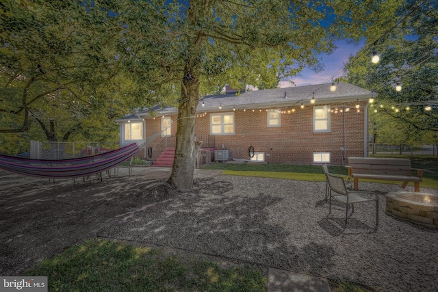 back of house featuring an outdoor fire pit, brick siding, a patio, and central AC unit