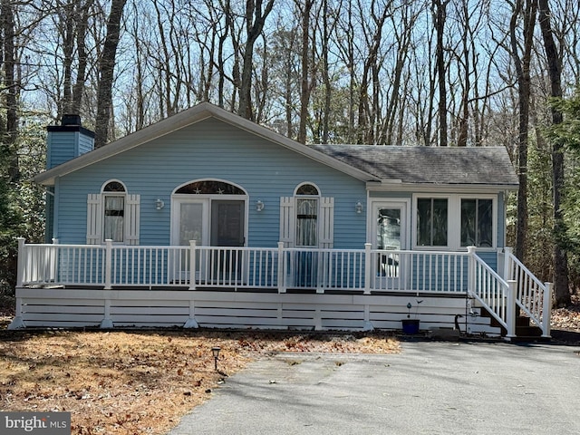 view of front of home featuring a porch and a chimney