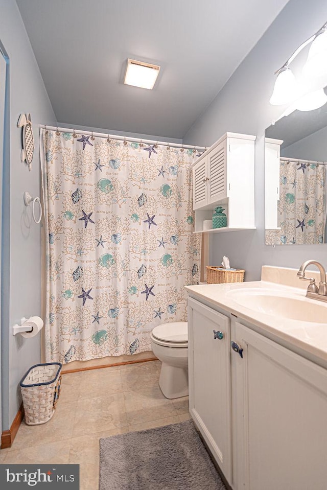 bathroom with curtained shower, toilet, and vanity